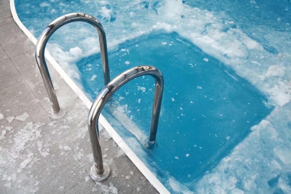 pool with chunks of ice damaging it from not being covered and protected
