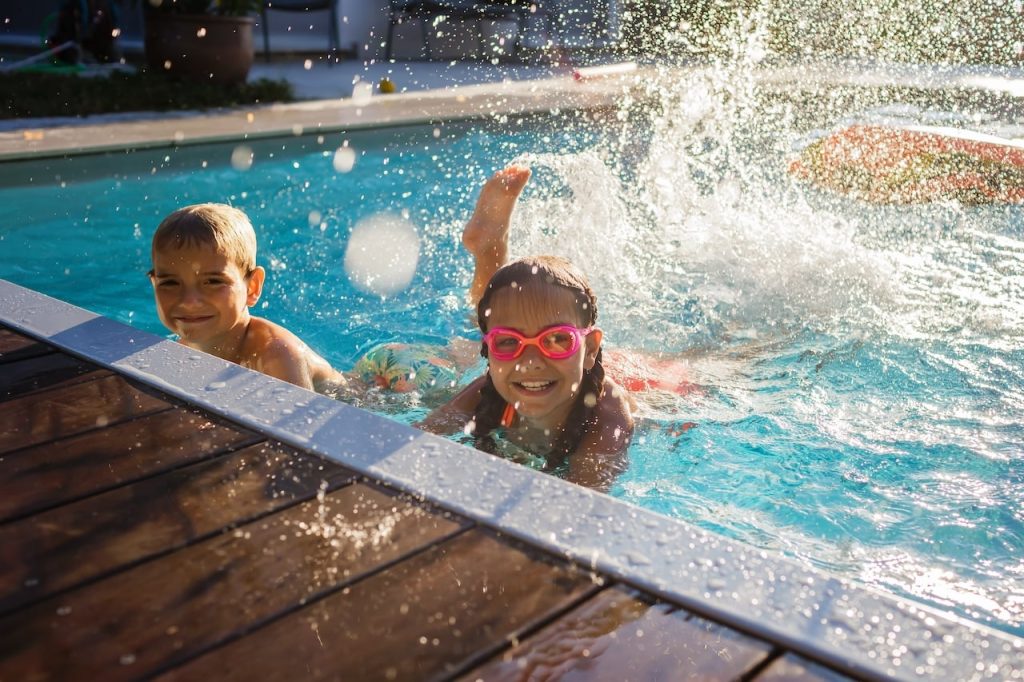 kids playing and splashing in a pool that is protected annually from freezes